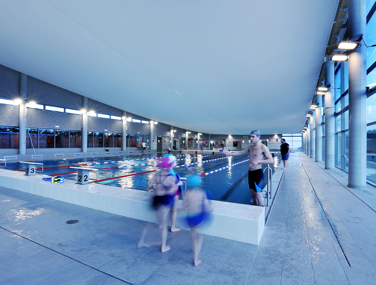 Intelligent lighting solution adapts levels to natural levels outside, reducing energy costs for this swimming pool